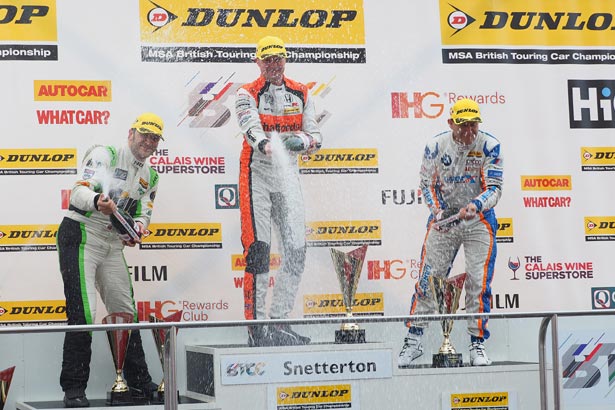 Gordon Shedden takes the top step of the podium after last lap victory